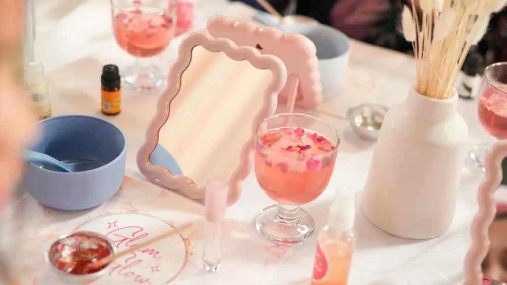 Glam & Glow spa table with a scalloped mirror and pink drinks