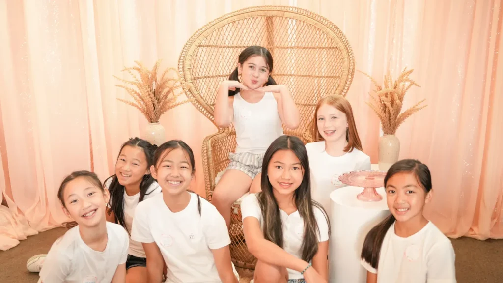Smiling kids posing around the rattan peacock chair at a birthday party