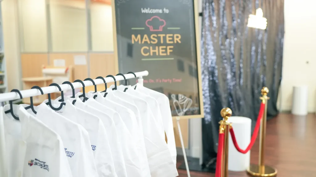 Master Chef welcome sign and a rack of chef coats ready for the guests
