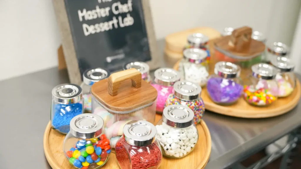 Master Chef Dessert Lab table with jars of sprinkles and candy toppings