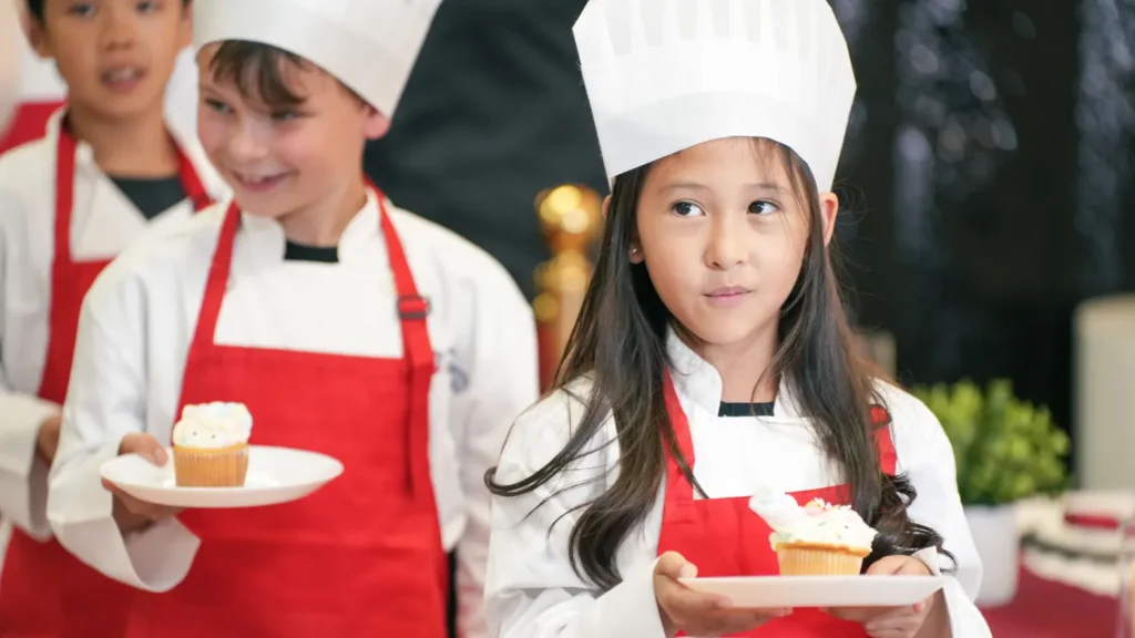 Young chefs carrying the cupcakes they decorated